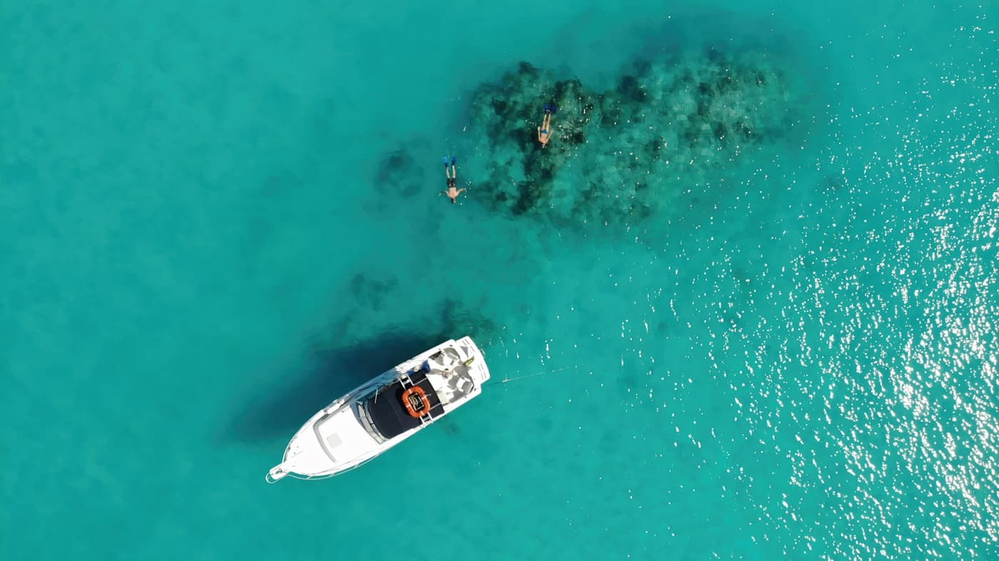 Catamaran and swimmers in turquoise water