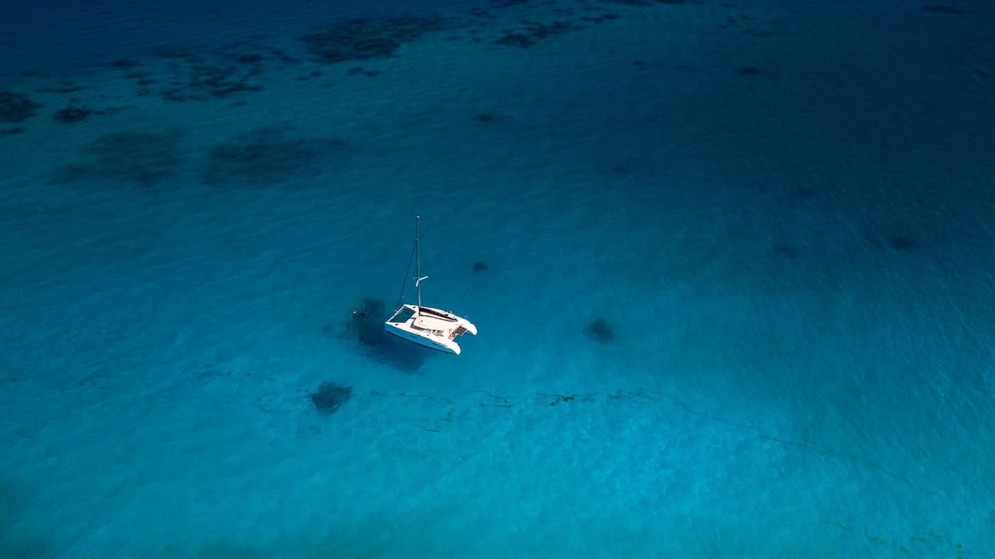 Private catamaran at anchor in clear water